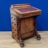 A Victorian walnut Davenport Desk with hinged top enclosing letter rack, the sloping front enclosing