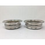 A pair of modern silver wine bottle Coasters with pierced design and wooden bases, 5 3/4in Diameter,