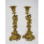 A pair of ormolu Candlestick with figural columns of boy and girl winged cherubs on dolphin supports