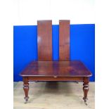 A Victorian mahogany extending Dining Table on turned supports with two spare leaves 7ft 6in W