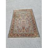 A bordered Persian Rug with central field of vase of flowers and further flowers on sage green