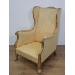 A gilt framed winged Occasional Chair with carved top rail, yellow upholstery and cushion on