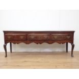An 18th Century oak Dresser Base with three drawers above a shaped frieze on cabriole front legs,