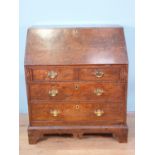 An 18th Century elm Bureau, the interior fitted cupboard, drawers, pigeon holes and well, above