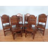 A set of six oak Dining Chairs by Bylaws in the 18th Century style with arched panelled backs, solid