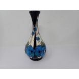 A Moorcroft baluster Vase with tube lined decoration of stylised flowers on a cream ground, 9 1/