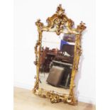 A 19th Century gilt Wall Mirror in the rococo manner with asymmetrical leafage scroll surmount and