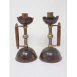 A pair of Arts and Crafts brass and copper Candlesticks in the manner of Christopher Dresser with