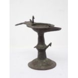 An antique Indian bronze Orissa Oil Lamp with bird finial on circular base 6 1/4in H
