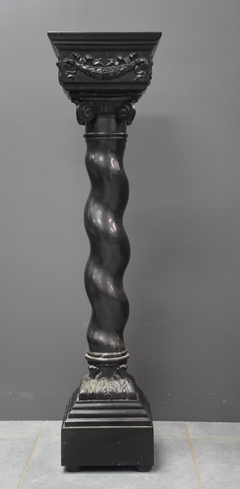 A black twisted marble column, carved with a capital and garlands. Napoleon III period.