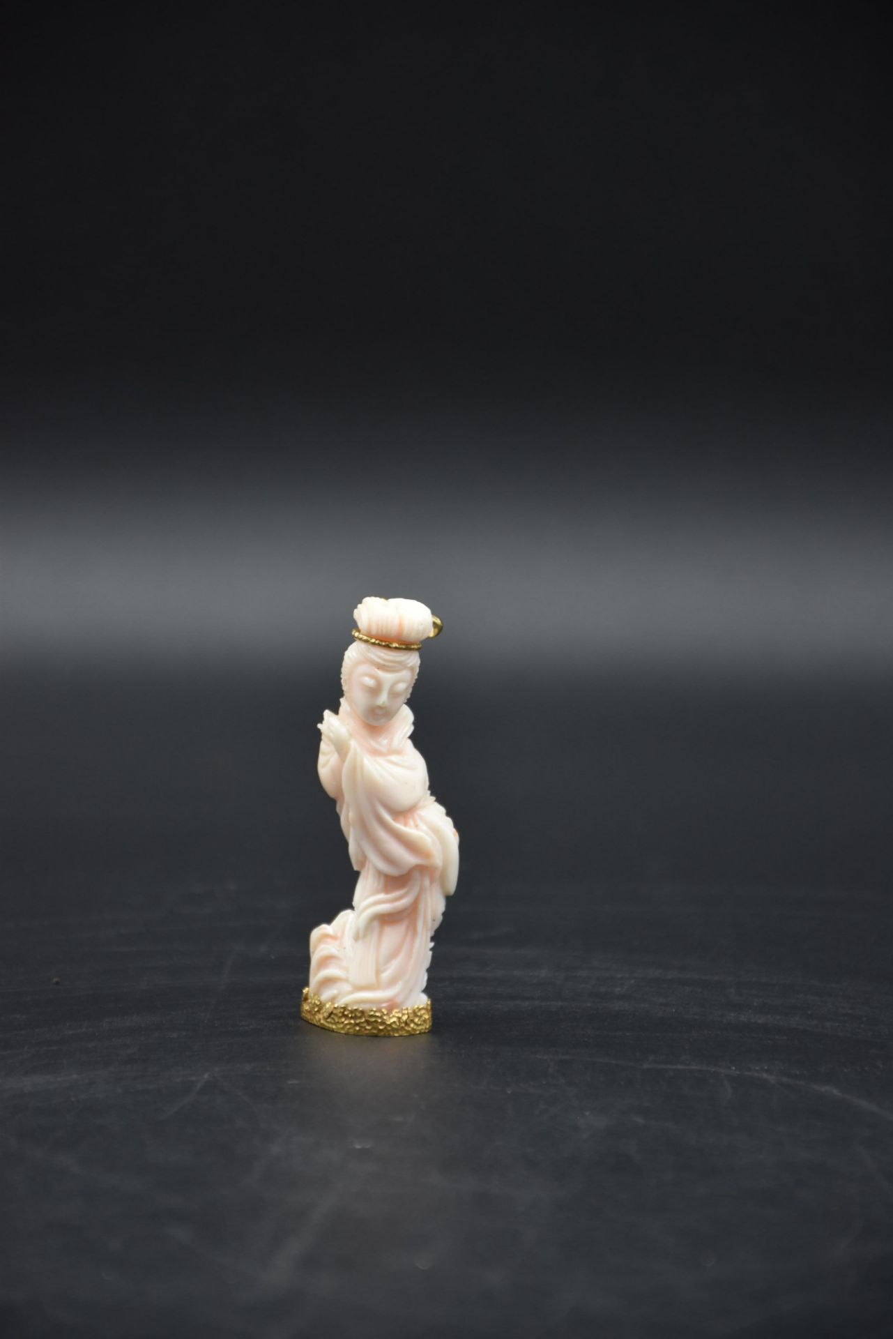 Carved coral with a base and an eagle's head hallmarked 18 K gold clasp. Height: 7 cm.