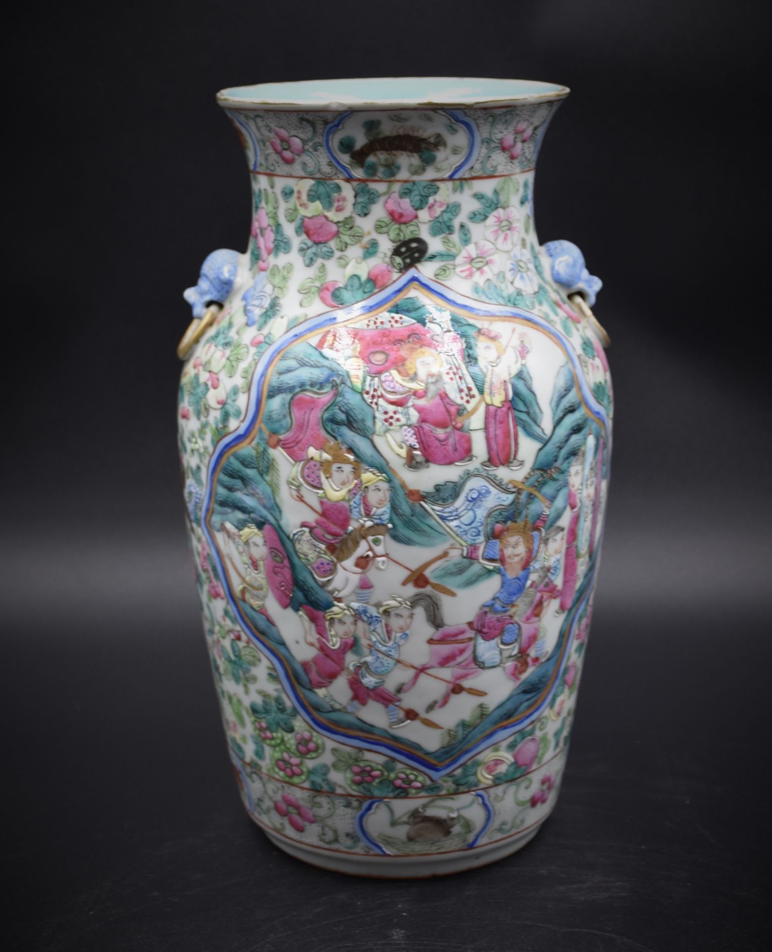 A Chinese porcelain vase decorated with court scenes and warriors. Height : 30 cm. A chip on the