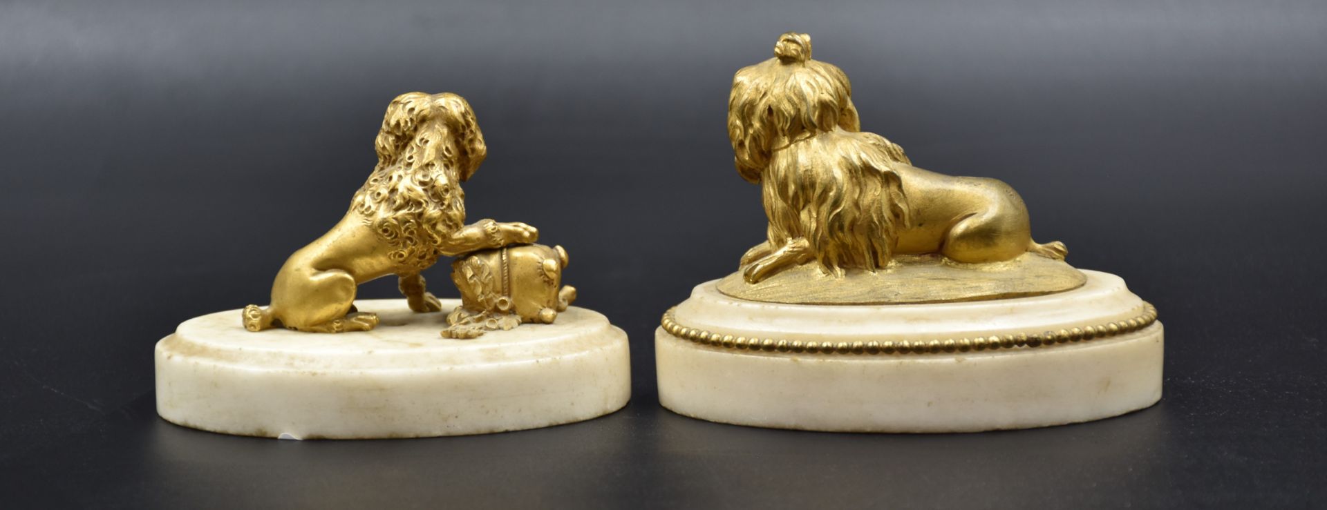 A pair of gilt bronze dogs on white marble bases. Late 18th century. One dog to be reattached. Total - Image 2 of 4