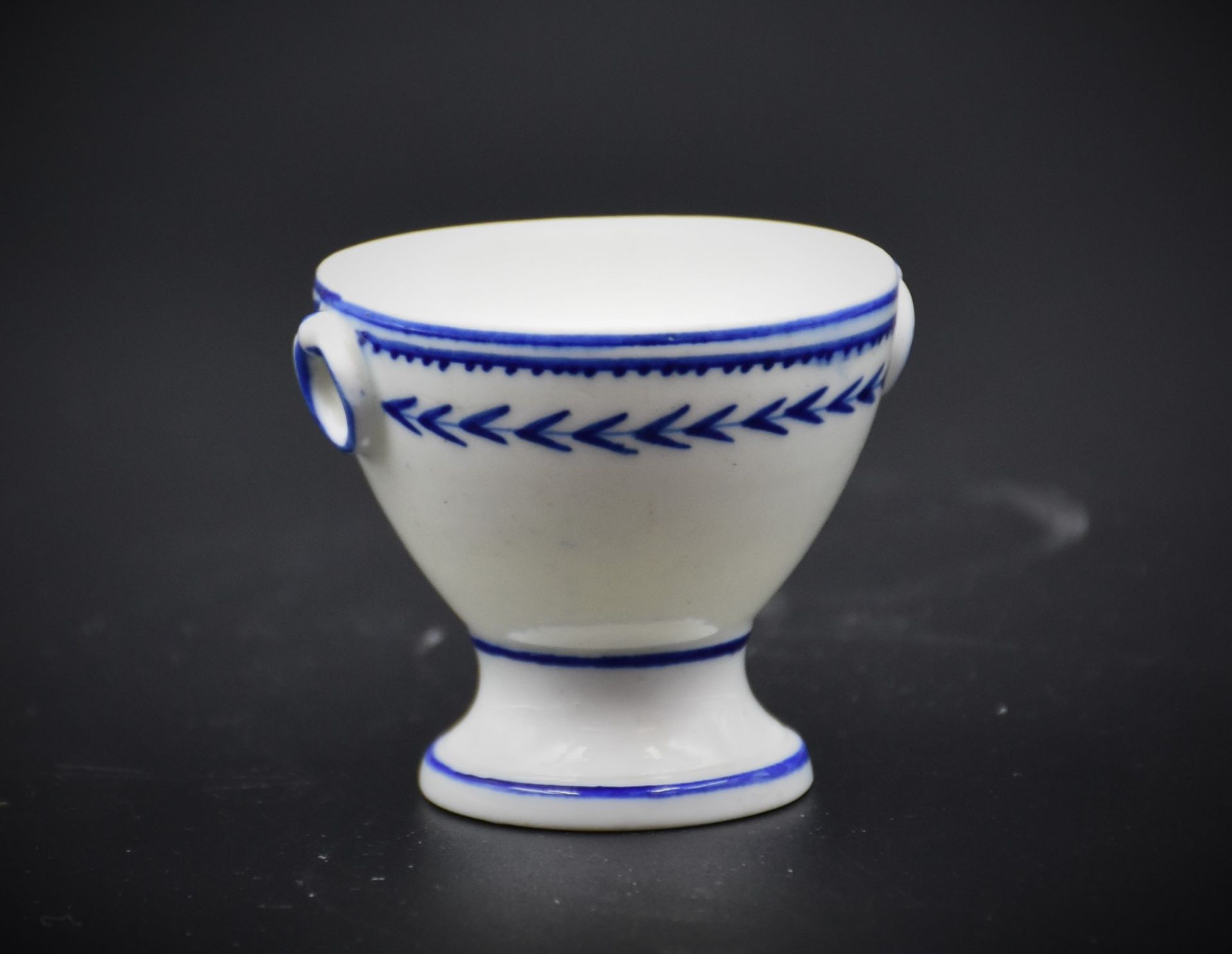 Egg cup in porcelain of Tournai, decoration with the ear and small side handles. Height : 4,5 cm.