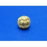 A small carved wooden pig form netsuke