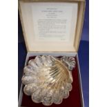 A hallmarked silver chased shell sweet meat dish in presentation box. 13.5cm x 12cm total weight 115