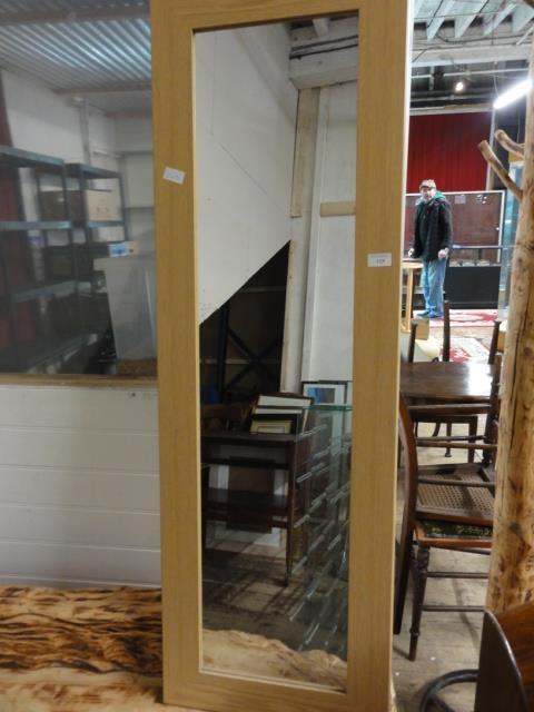 A light wood framed wall mirror unable to post