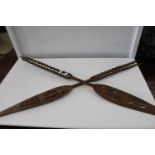 A pair of African wooden decorative spears (one at fault)