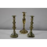 Three antique brass candlesticks pair 25cm tall
