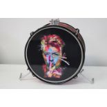 A novelty drum clock with David Bowie clock face