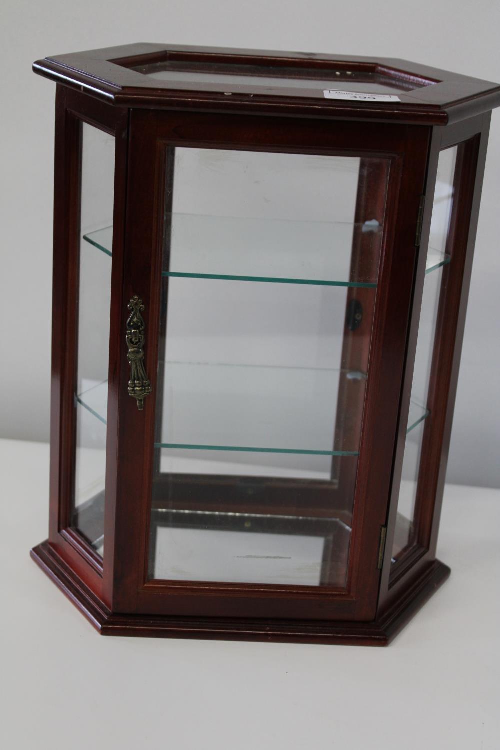 A small wooden jewellery cabinet with glass shelves
