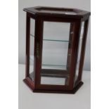 A small wooden jewellery cabinet with glass shelves