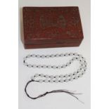 A Chinese cinnabar box with a jade necklace