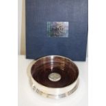 A boxed & hallmarked silver and wooden wine bottle coaster