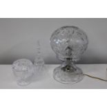Three pieces of cut glass including a hurricane style electric lamp