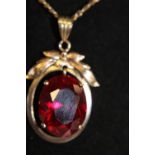 A large Ruby in a 14ct gold pendant on a 9ct gold chain