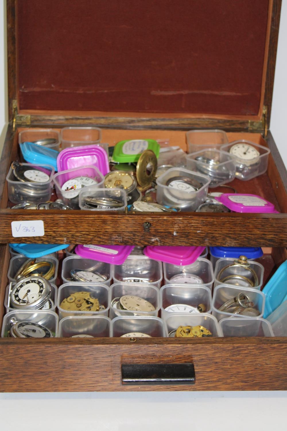 A box of assorted pocket watch parts & other.