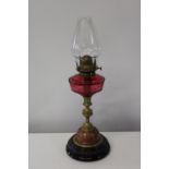 A nice quality brass & copper oil lamp with a cranberry glass reservoir. h50cm