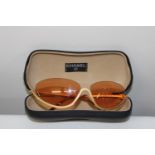 A pair of genuine Chanel sunglasses with orange tinted lenses & with half frames in original box