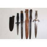 A collection of four knives including two fighting knives