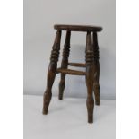 An antique Elm four legged stool. Height 53cm