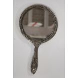 A vintage white metal hand held mirror