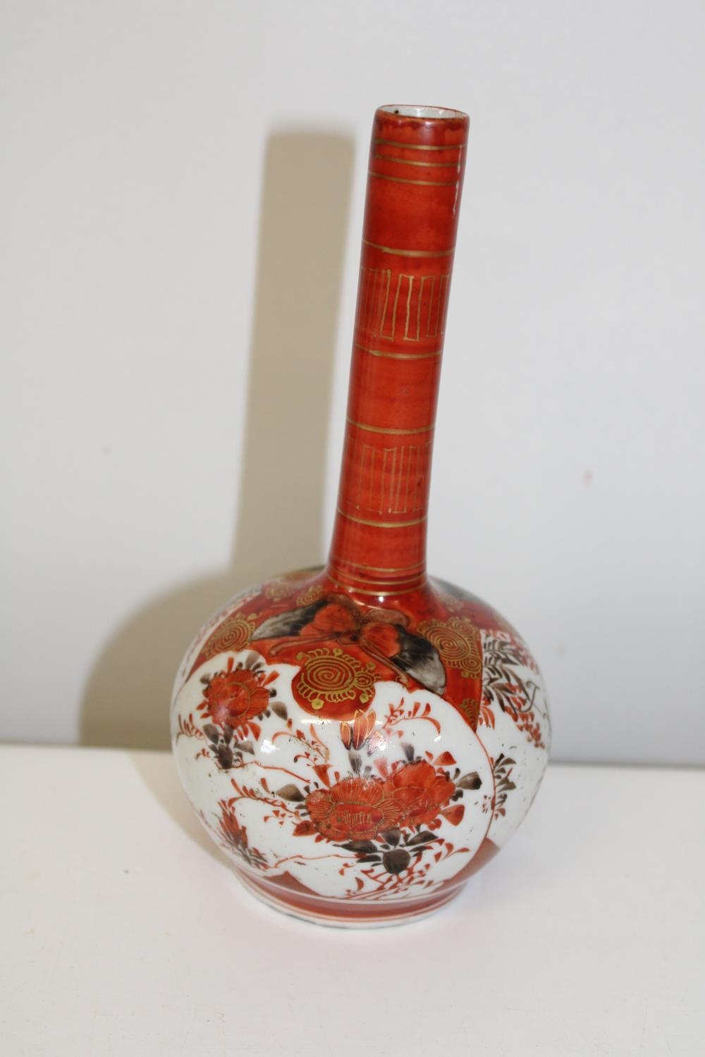 A Japanese Mieji period bottle vase decorated with butterflies & foilage (sold as seen) Height 17cm