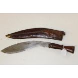 A large Kukri Gurka style knife with a wooden handle in a leather sheath Length of knife 46cm