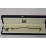 A Royal Mint diamond & sapphire pendant & silver T Bar chain with signs of ware