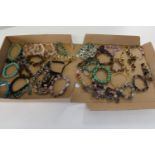 A large selection of semi-precious stone necklaces including jade, amethyst & tigers eye