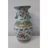 A large Chinese porcelain butterfly vase with foo dog handles. With marks to base. Sold as seen