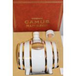 A sealed and cased bottle of Camus Napoleon cognac in a porcelain cask