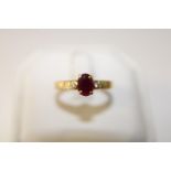 A 18ct gold ruby solitaire ring set with diamonds