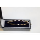 A boxed 9ct gold diamond & sapphire bangle