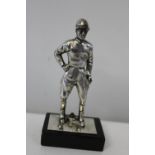 A white base metal jockey figure on stand inscribed 'The Best' 1949 12cm tall