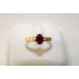 A 18ct gold ruby solitaire ring set with diamonds. size Q