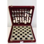 A carved bone chess set with inlaid board