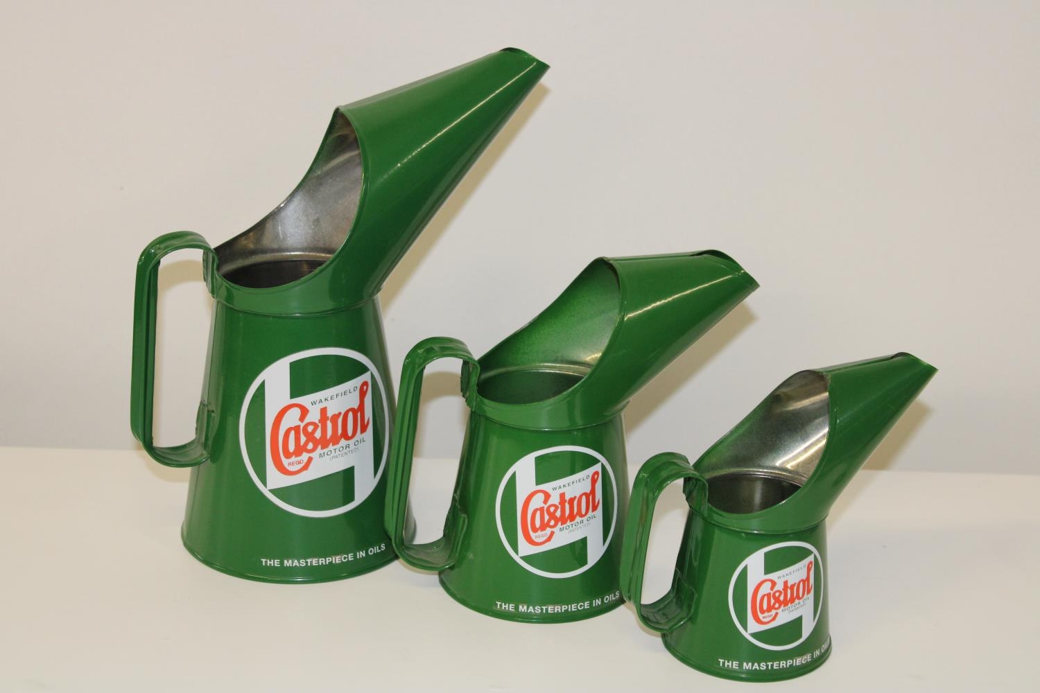 A set of three graduated reproduction Castrol oil cans