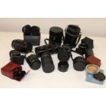 A box of assorted camera lenses etc
