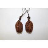 Two Chinese carved walnut pendants
